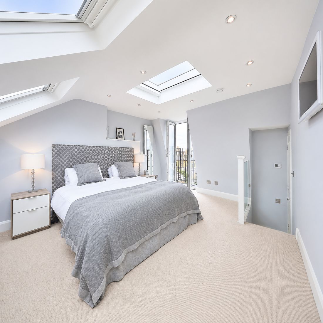 A loft bedroom under the ridge, rooflight over the bed